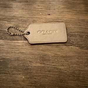 light brown leather Coach New York hangtag with a silver-tone ball chain